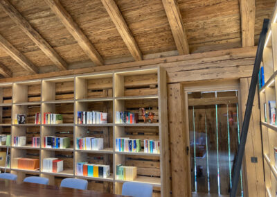 Bibliothek mit Massivholzregalen und Holzbalkendecke – stilvoller Innenausbau in Schreinerqualität.