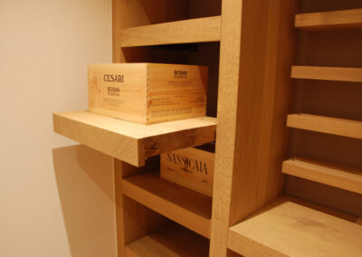 Detailaufnahme von Holzregalen im Weinkeller – funktionaler Innenausbau aus massivem Holz.