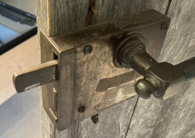 Detailaufnahme des massiven Schlosses einer rustikalen Massivholztüre. Schreinerhandwerk mit Liebe zum Detail.