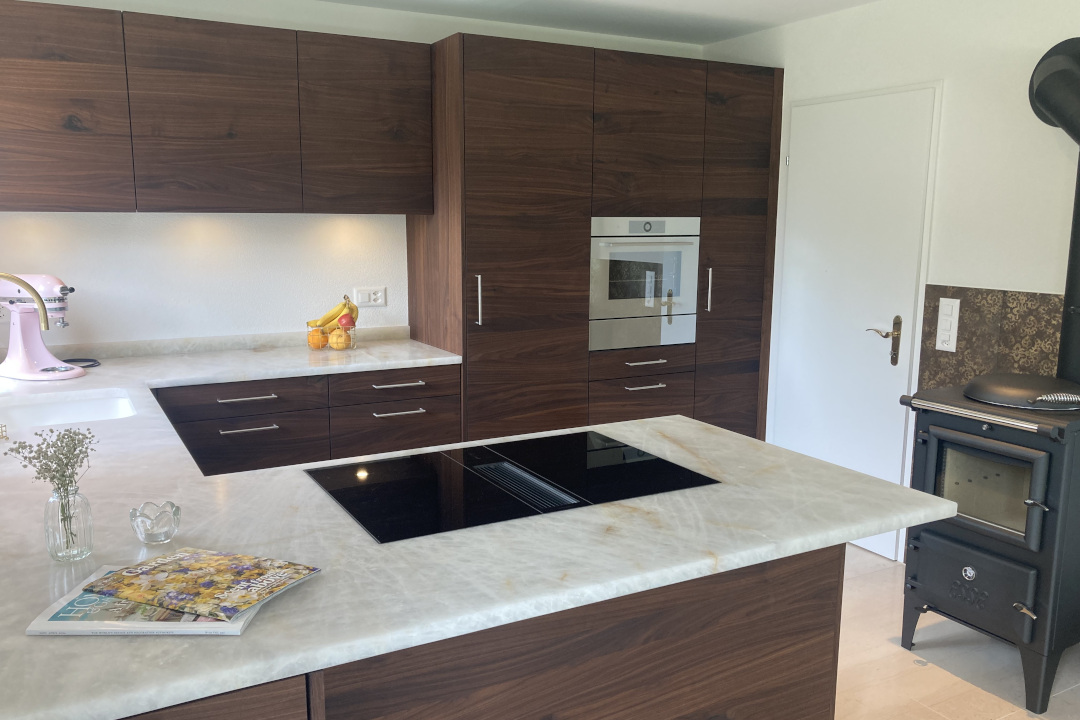 Elegante Schreinerküche aus Nussbaum mit Naturstein-Arbeitsplatte – handgefertigte Qualität und edles Design