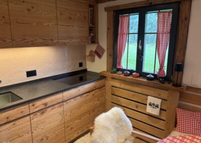 Lärchenküche Chiavenna mit gehackten Holzfronten und langer Arbeitsfläche am Fenster